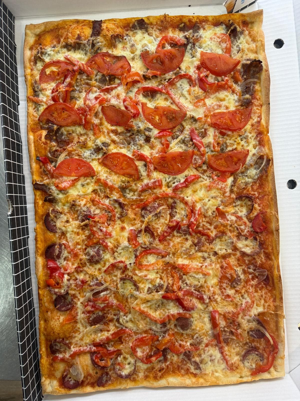 Familienpizza mit Tomaten und Paprika