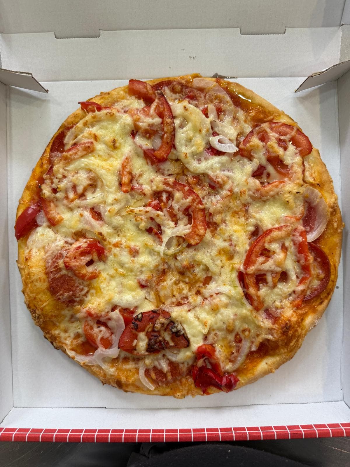 Runde Pizza mit Tomaten und Zwiebeln